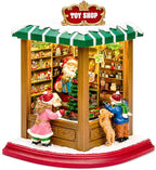 MOMENTS IN TIME Lighted Santa’s Christmas Village Shop LED Lights, Music & Animation Battery Operated 8.8” Holiday Building Christmas Decoration